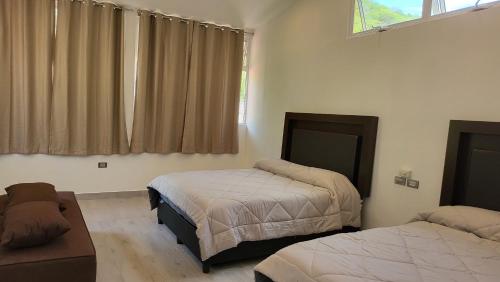 a bedroom with two beds and a window at Rancho El Venado Termales in Acatic
