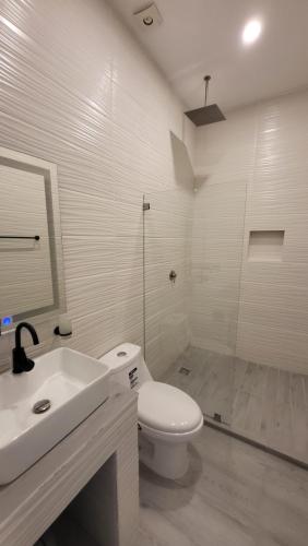 a bathroom with a toilet and a sink and a shower at Rancho El Venado Termales in Acatic