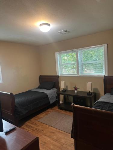 Un dormitorio con dos camas y un escritorio y ventana. en Home Away From Home, en Decatur