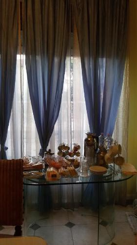 a table with food on it with blue curtains at Villa Fiorita in Monfalcone