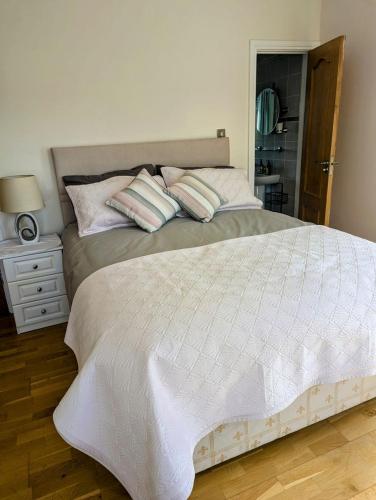 a bedroom with a large white bed with pillows at Double Bedroom in Ryefield
