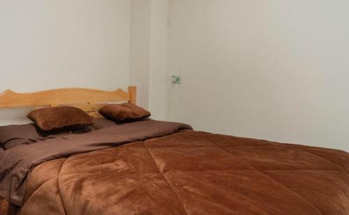 a bedroom with a large bed with two pillows at Casa Tsao in Bogotá
