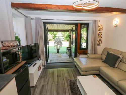 a living room with a couch and a tv at Moor Cottage in Oldham