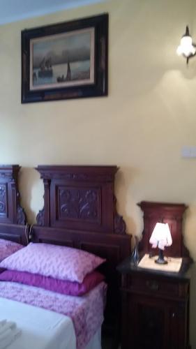 a bedroom with a bed and a table with a lamp at Villa Fiorita in Monfalcone
