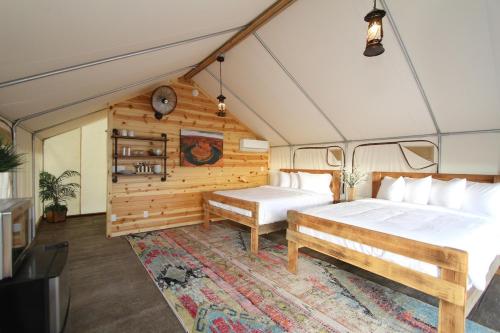 a bedroom with a bed and a bench in a room at Glamping Tent #7 with AC Heat AC and Private Bath in Orderville