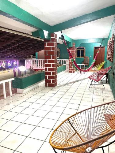 a patio with chairs and hammocks on a building at Hotel Casa Verde in Troncones