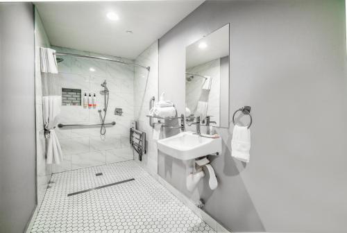 a white bathroom with a sink and a shower at Rodeway Inn South Gate - Los Angeles South in South Gate