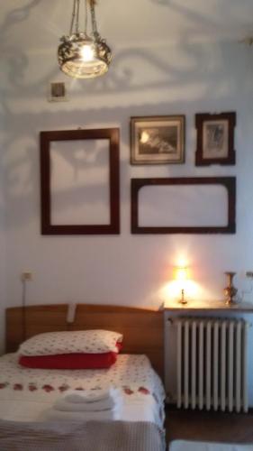 a bedroom with a bed and a lamp and pictures on the wall at Villa Fiorita in Monfalcone