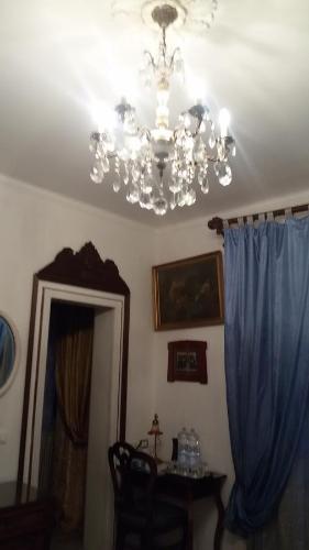 a chandelier in a room with a table and a mirror at Villa Fiorita in Monfalcone