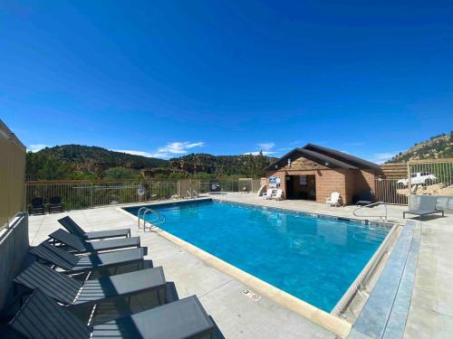 a swimming pool with lounge chairs and a house at Glamping Tent #7 with AC Heat AC and Private Bath in Orderville