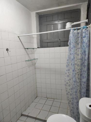 a bathroom with a shower curtain and a toilet at Katai in Salvador