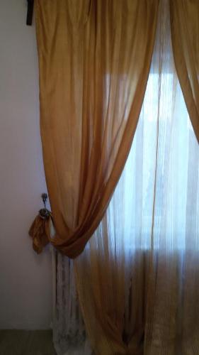 a window with a curtain in a room at Villa Fiorita in Monfalcone