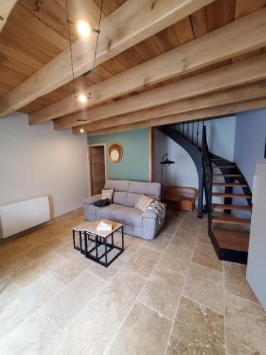 un salon avec un canapé et un escalier dans l'établissement Chez Émile la suite, maison 2 chambres à la campagne, à Humes