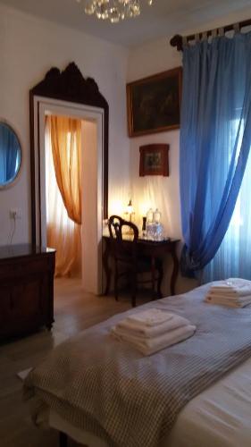 Villa Fiorita في مونفالكوني: غرفة نوم بسرير والستائر الزرقاء وطاولة