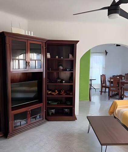 a living room with a entertainment center with a television at Casa Ceiba, un hogar para tu familia in Santa Cruz Huatulco