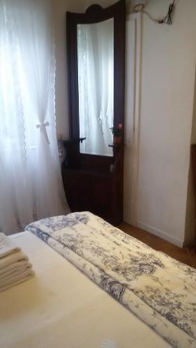 a bedroom with a bed and a window with a curtain at Villa Fiorita in Monfalcone