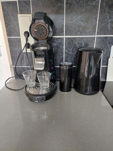 a coffee maker and two cups on a counter at JaBaKi Garden House in Hoofddorp