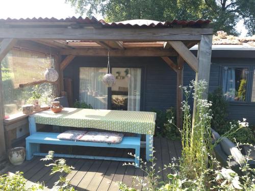 a picnic table under a pergola on a deck at Voorthuizen chalet nabij de bossen in Batoʼs Erf