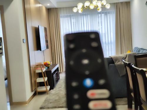 a remote control in front of a hotel room at Lola's Haven - 75" Screen, Heated Pool, Gym, Views in Nairobi
