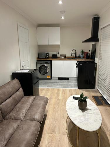a living room with a couch and a table at Orbit guest house in Horne