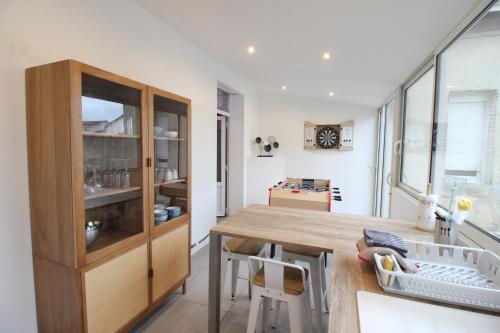 une cuisine avec une table en bois et une salle à manger dans l'établissement Plain-Pied - 5 couchages - Billard - BabyFoot - Terrasse - Jardin - Véranda - 4 chambres & canapé convertible - Netflix - Amazon Prime - WIFI - Stationnement gratuit devant - Verdun Centre - Géré par Presta-Zen'Services, à Verdun-sur-Meuse