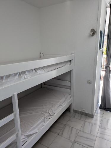 - une étagère blanche dans une chambre avec lavabo dans l'établissement Appartement Valras - Bord de mer, à Valras-Plage