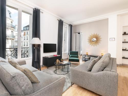 un salon avec deux canapés et une télévision dans l'établissement LivinParis - Luxury 3 Bedrooms Le Louvre I, à Paris