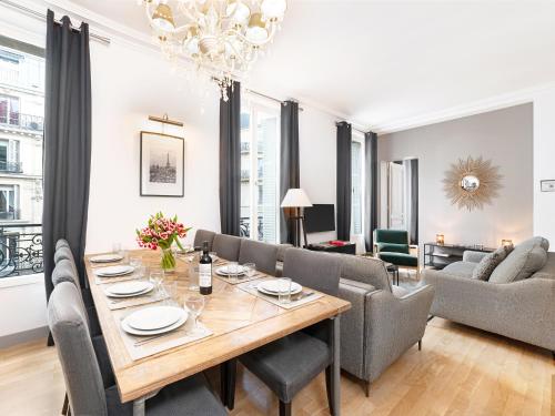 une salle à manger et un salon avec une table et des chaises dans l'établissement LivinParis - Luxury 3 Bedrooms Le Louvre I, à Paris