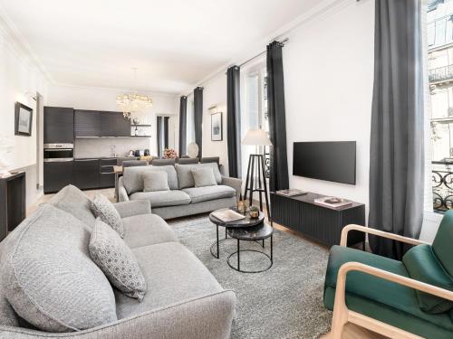 un salon avec un canapé et une télévision dans l'établissement LivinParis - Luxury 3 Bedrooms Le Louvre I, à Paris