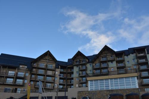 an apartment building with a blue sky in the background at Résidence Les Adrets de Peyragudes in Germ