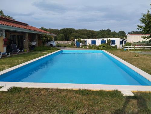 a large blue swimming pool in a yard at Casa da aldeia in Amor