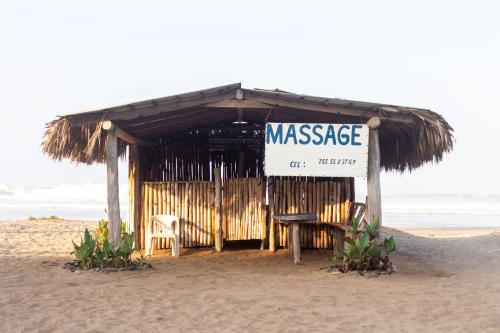 a small shack on the beach with a massage sign at Hotel Tres Santos in Troncones