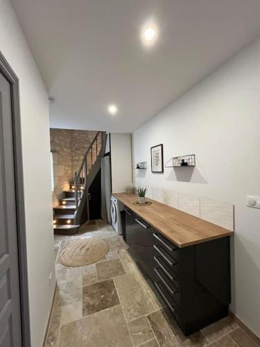 eine Küche mit Theke und ein Flur mit Treppe in der Unterkunft Charmante maison de bourg cosy accès wifi in Sepmes
