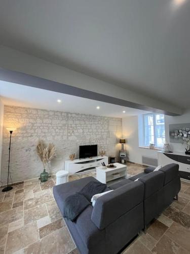 un grand salon avec un canapé et une télévision dans l'établissement Charmante maison de bourg cosy accès wifi, à Sepmes