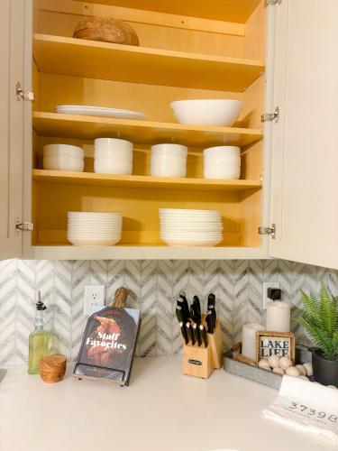 a kitchen cabinet with plates and utensils in it at Luxurious Lake Getaway in Winchester