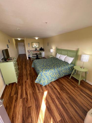 a bedroom with a bed and a wooden floor at The Moorings Hotel and Marina of Carrabelle in Davis Island