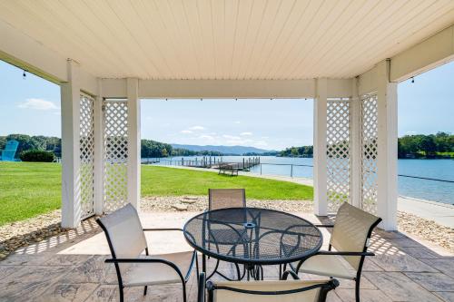 a table and chairs on a porch with a view of the water at Beach and Pool Access Smith Mountain Lake Getaway! in Huddleston