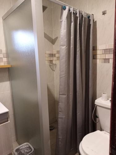 a bathroom with a shower curtain and a toilet at Appart MKD Abatta in Abidjan