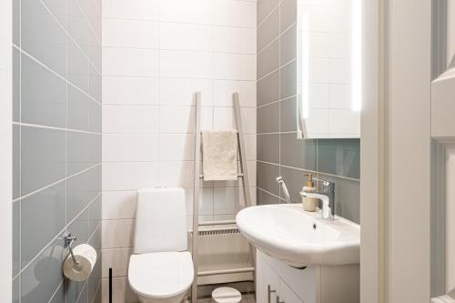 a white bathroom with a toilet and a sink at Luxurious Villa Snow with Jacuzzi in Rovaniemi