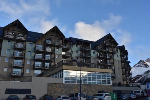 an apartment building with mountains in the background at Résidence Les Adrets de Peyragudes in Germ