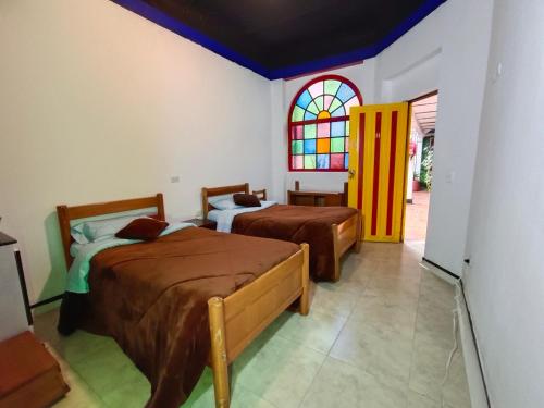 a bedroom with two beds and a stained glass window at Casa Tsao in Bogotá