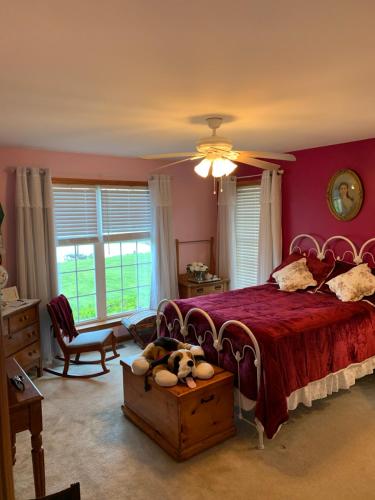 a bedroom with a red bed with stuffed animals on it at 3 guest rooms 2 shared baths in Milford