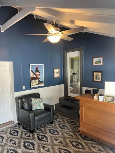a living room with a ceiling fan and a chair at Yardarm Motel in Searsport