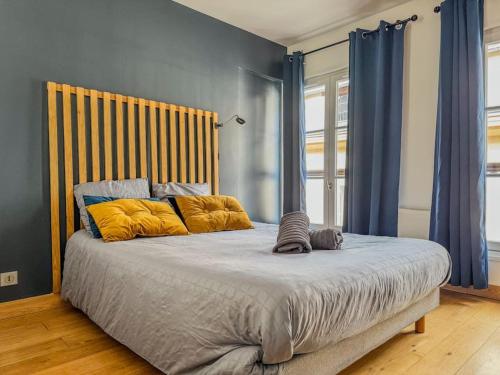 une chambre avec un grand lit avec des oreillers jaunes dans l'établissement Appartement moderne dans le centre de Chartres, à Chartres