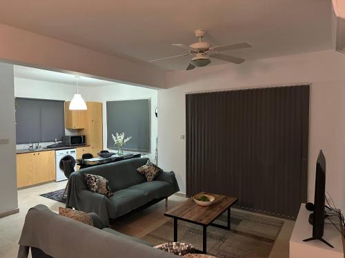 a living room with a couch and a ceiling fan at Sirena Sunrise, Apartment 4 in Paphos