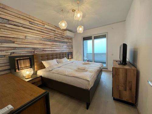 a bedroom with a large bed with a brick wall at City Vibe Apartments in Someşeni