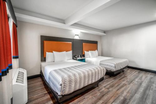 a hotel room with two beds and a window at Rodeway Inn South Gate - Los Angeles South in South Gate