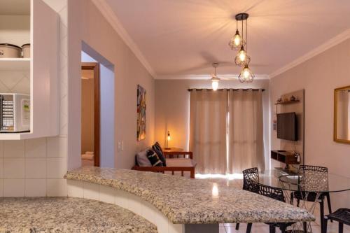 a kitchen and living room with a table and chairs at Edifício Belluno in Ribeirão Preto