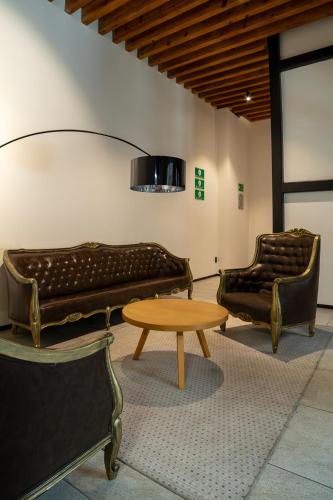two leather couches and a table in a room at Casa de la Luz Hotel Boutique in Mexico City