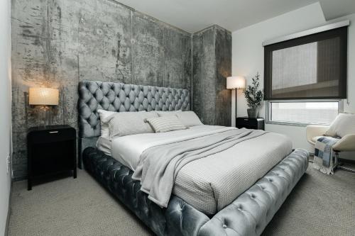 a bedroom with a large bed with a leather headboard at Hollywood Designer Apartment in Los Angeles